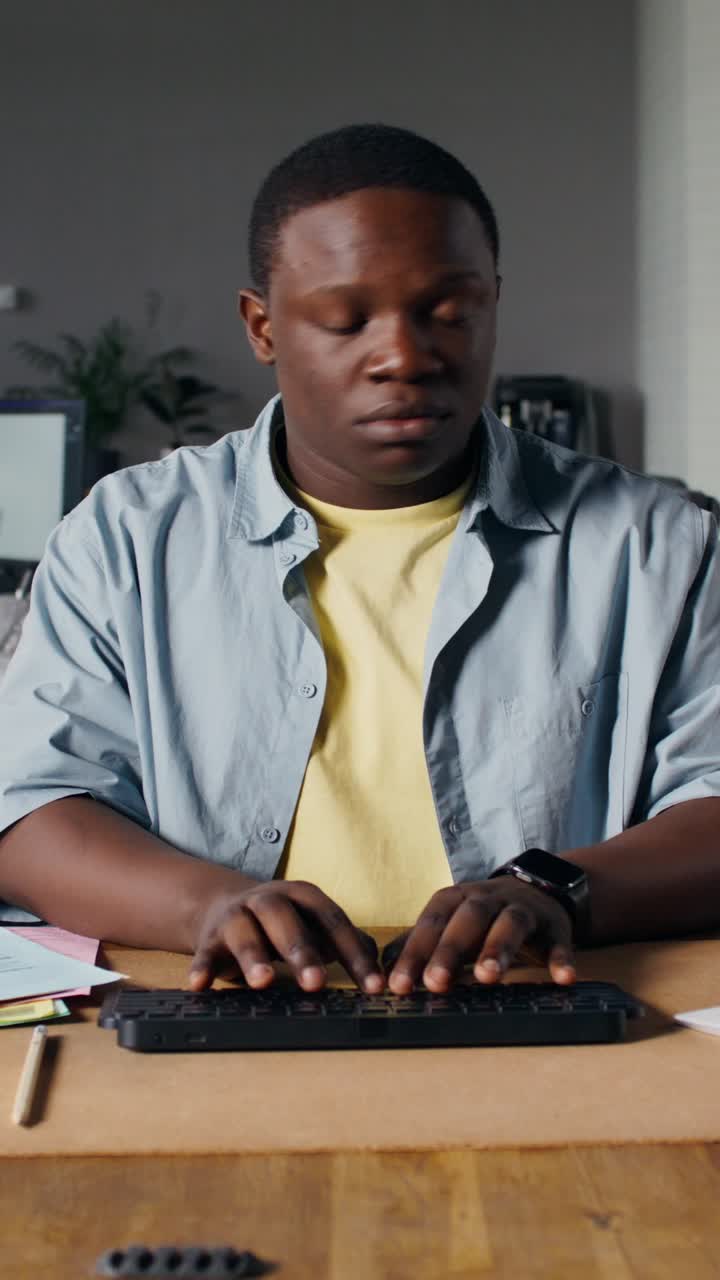 Man Typing on a Keyboard at a Desk