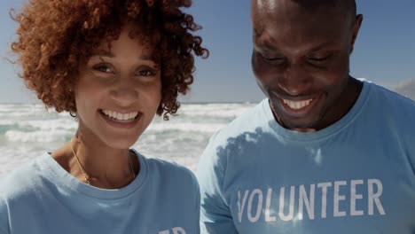 Volunteers looking at clipboard on the beach 4k