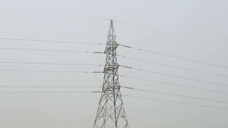 A-zoom-out-shot-of-high-voltage-electric-wire-pylons-against-a-grey-sky-creates-a-dramatic-industrial-visual