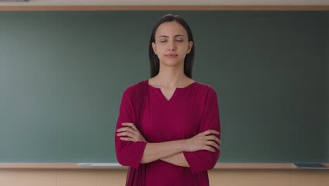 retrato de una maestra india de pie con las manos cruzadas