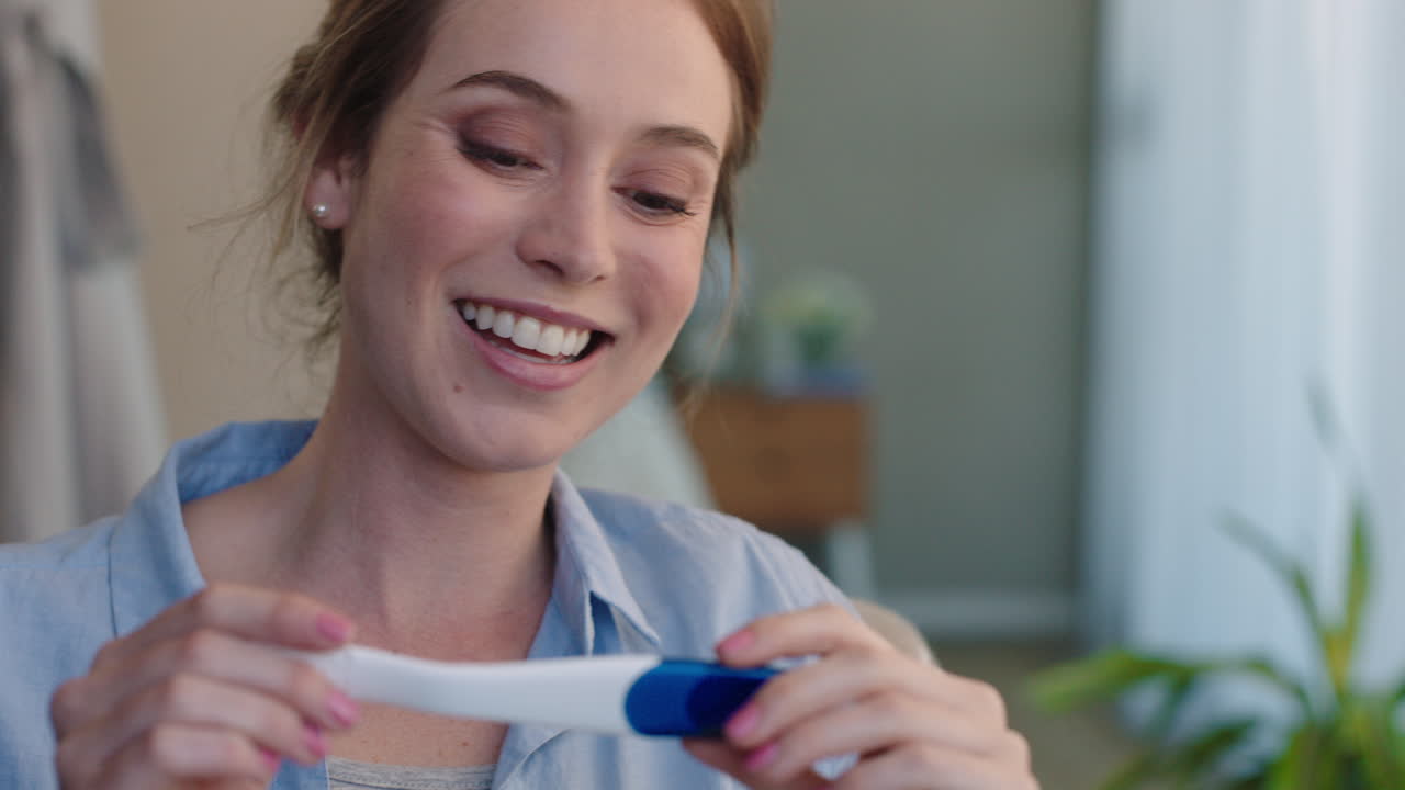portrait beautiful woman looking at pregnancy test enjoying surprise result showing positive excited for motherhood