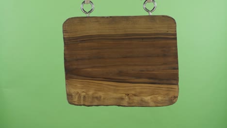 panorama. old wooden sign hanging from a rope. isolated on green background