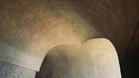 stone tunnel with arched ceilings and lighting