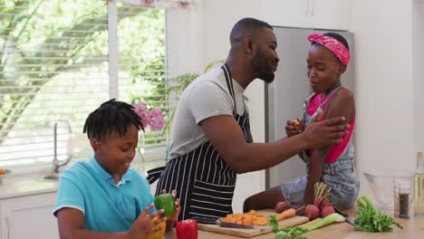 Afroamerikanischer-Vater-Umarmt-Seine-Kinder-Zu-Hause-In-Der-Küche