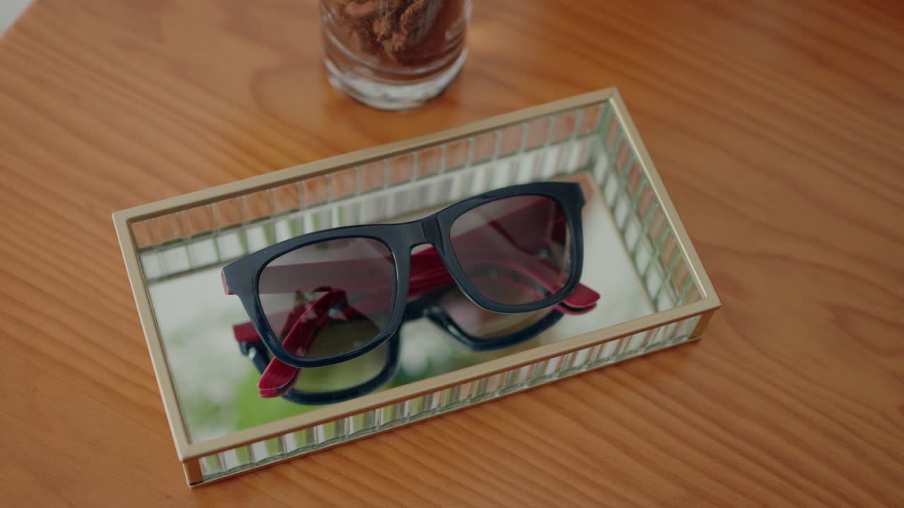 gafas de sol elegante en una caja de vidrio en una mesa de madera con luz natural