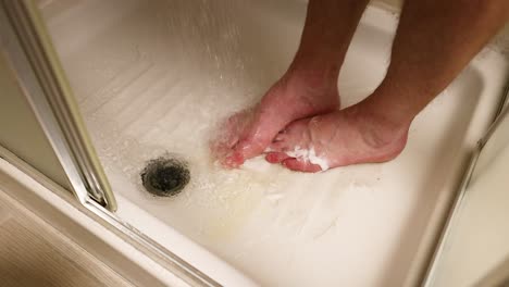 person washing feet in a shower