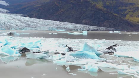 slow orbiting shot showing the impact climate change has on the fjallsárlón glacier