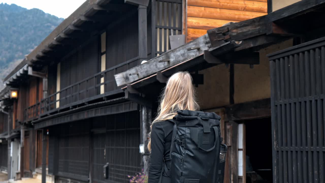 A captivating stock video of a girl walking through the picturesque streets of Tsumago, a historic town along the Nakasendo Trail.