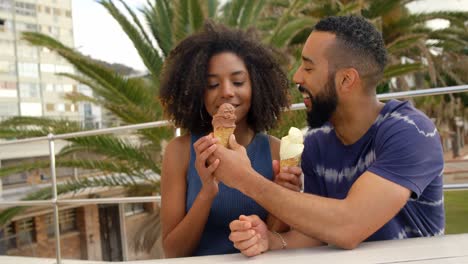 Couple-eating-ice-cream-cone-at-beach-4k