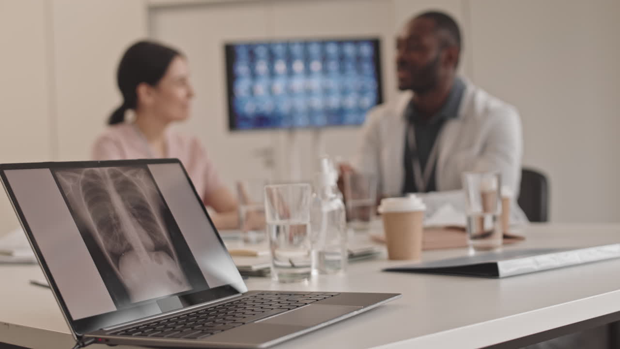 Doctors Discussing Chest X-Ray on Laptop