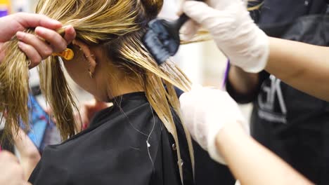 hairstylist applying hair smoothing product on a girls hair