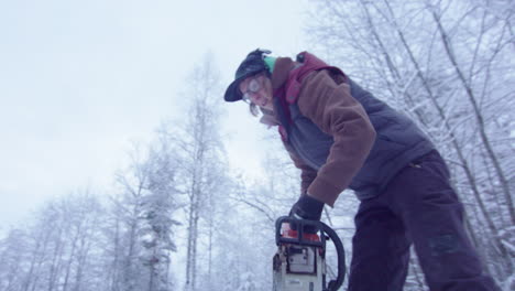 Handheld-Action---Frau,-Die-Mit-Einer-Kettensäge-Ein-Eisbadeloch-Schneidet