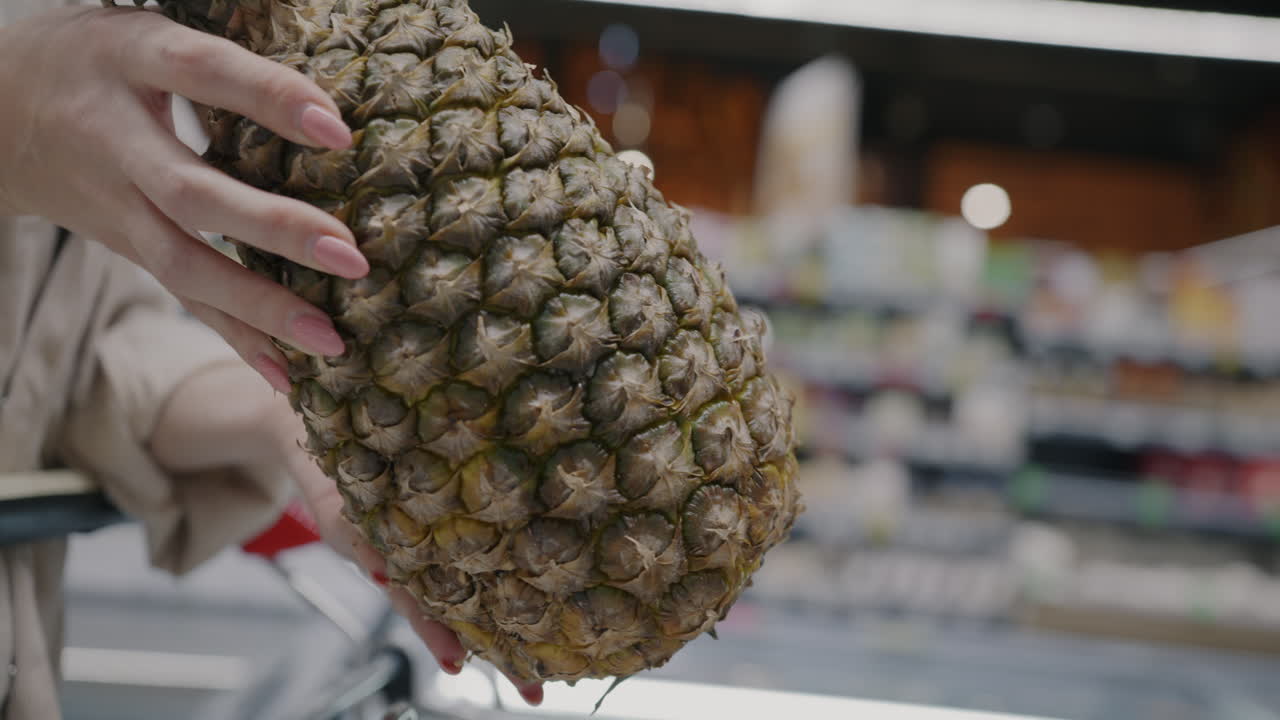 Woman buying a pineapple at a grocery store