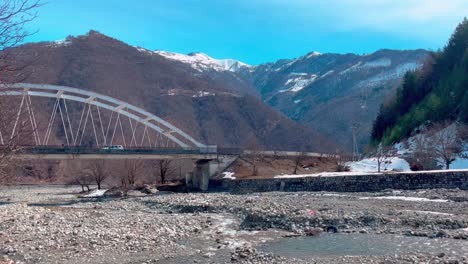 view of the bridge under which the river runs in a rocky bed