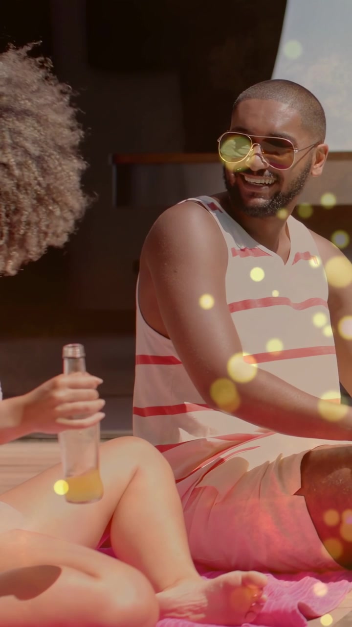 Donna che inizia un gesto e offre una bottiglia su un asciugamano rosa, uomo sorridente, bokeh dorato per il marketing.