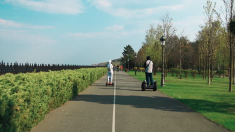 Junges-Paar-Bewegt-Sich-Auf-Dem-Segway-Im-Frühlingspark