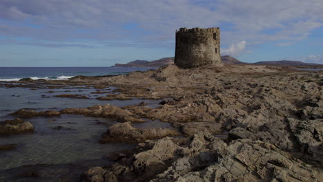 Isola-Della-Pelosa,-Cerdeña:-Vista-Aérea-A-Baja-Altura-Y-Alrededor-De-La-Torre-Que-Se-Encuentra-En-El-Sitio