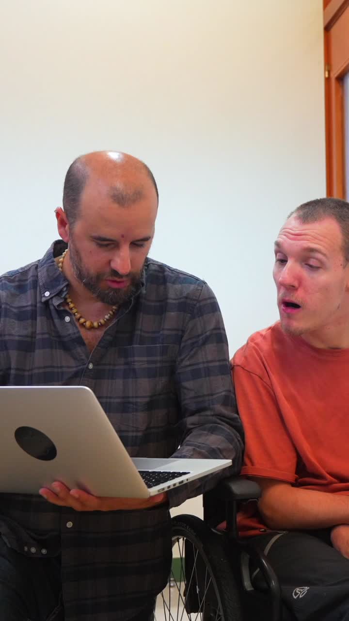 Two men collaborating on a laptop