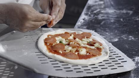 pizza being prepared in the dominican republic, showcasing the dough, ingredients, and preparation process