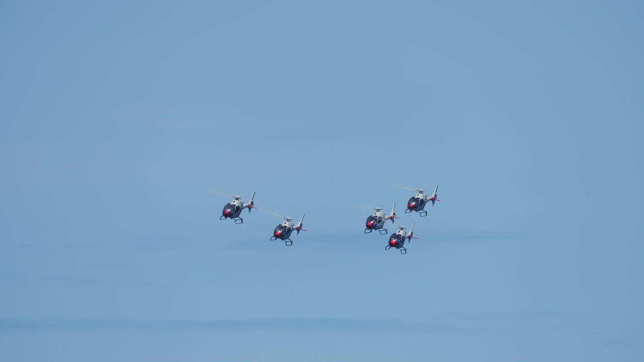 軍用ヘリコプターが澄み切った青空を編隊飛行