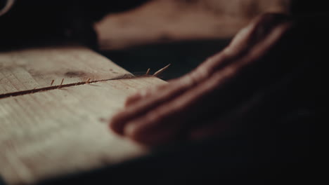 a slow motion of a carpenter cutting wood with a special machine