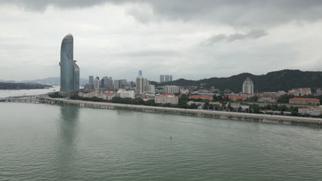 Shimao-Strait-Building-In-Southern-Xiamen-China-On-A-Cloudy-Afternoon-Drone-Tracking-Back-60FPS