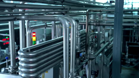 industrial equipment with metal tubes on a dairy factory. factory machinery with industrial pipes at a dairy food production plant. manufacturing process.