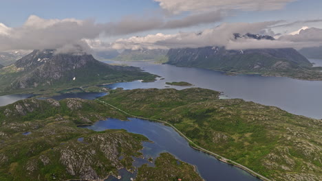 Djevelporten-Norway-Aerial-V3-Panning-View-In-Großer-Höhe-über-Der-Bucht-Von-Husvågen-Mit-Blick-Auf-Den-Hammerstad-Campingplatz,-Umgeben-Von-Berglandschaft-Und-Küstenbucht---Aufgenommen-Mit-Mavic-3-Cine---Juni-2022