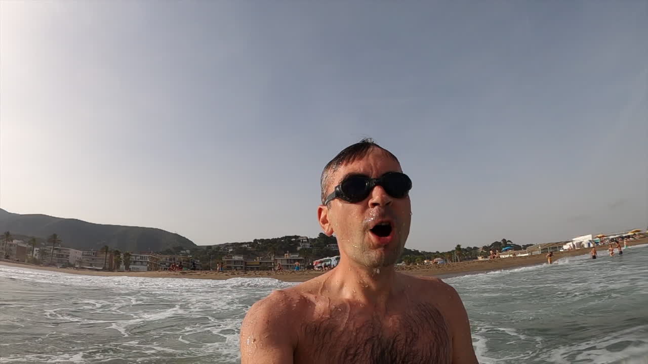 Man wearing swimming googles swimming in the sea