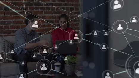 animación de la red de iconos de personas sobre un colega masculino y femenino trabajando con una computadora portátil