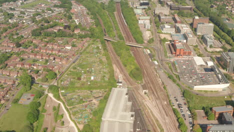 Toma-Aérea-Sobre-El-Tren-Del-Suroeste-Que-Llega-A-Las-Afueras-De-La-Ciudad-De-Basingstoke.