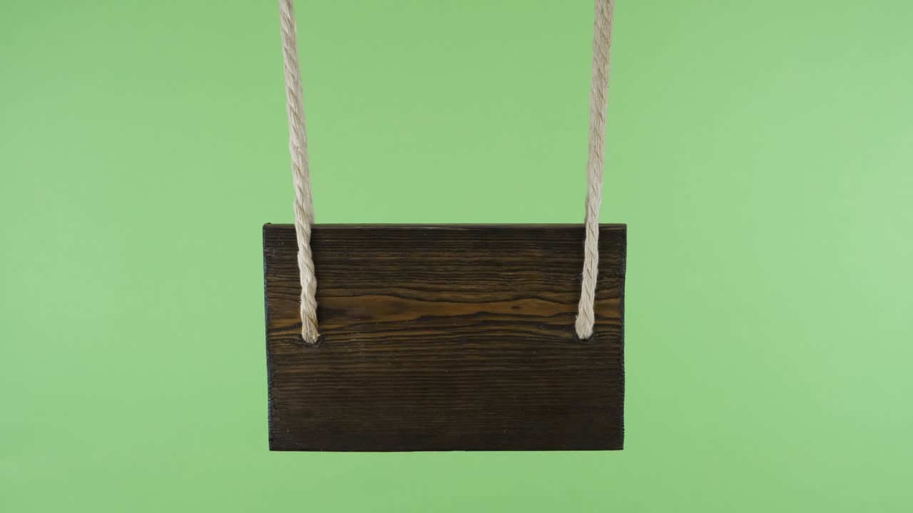 Puntatore in legno che oscilla al vento. Isolato su schermo verde.