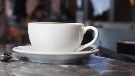 a white coffee cup on a marble counter