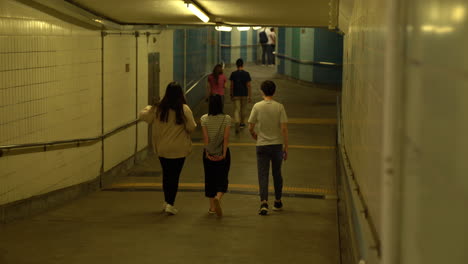 people walking through an underground subway passage