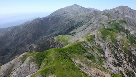 Vista-Aérea-De-Drones-De-La-Cima-De-Una-Alta-Cordillera-Con-Cielo-Azul-Claro