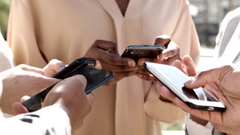 cropped view of young people using smartphones