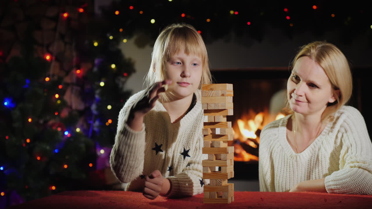 mamá e hija juegan un juego de mesa con bloques de madera