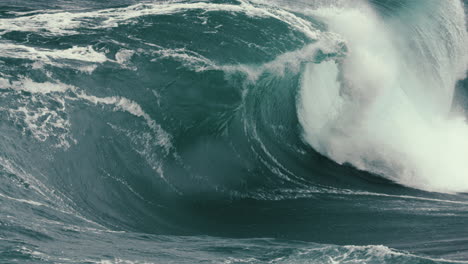 Foamy-wave-breaking-in-slow-motion-close-to-rocks