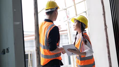 4k panning . a young male and female asian civil engineers holding a tablet and working together