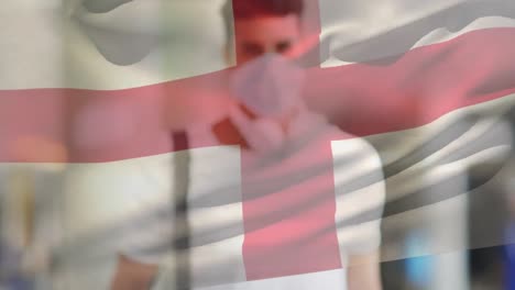 animación de la bandera de inglaterra ondeando sobre un hombre que usa una máscara facial durante la pandemia de covid-19