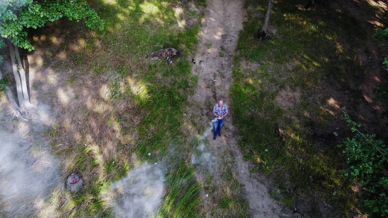 hombre con una bomba de humo blanco en el bosque