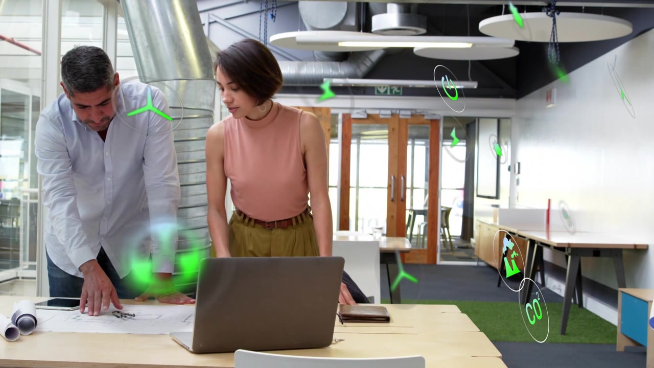 Compañero de trabajo masculino señalando planos, diseñadora utilizando superposiciones verdes dinámicas mostrando datos de diseño
