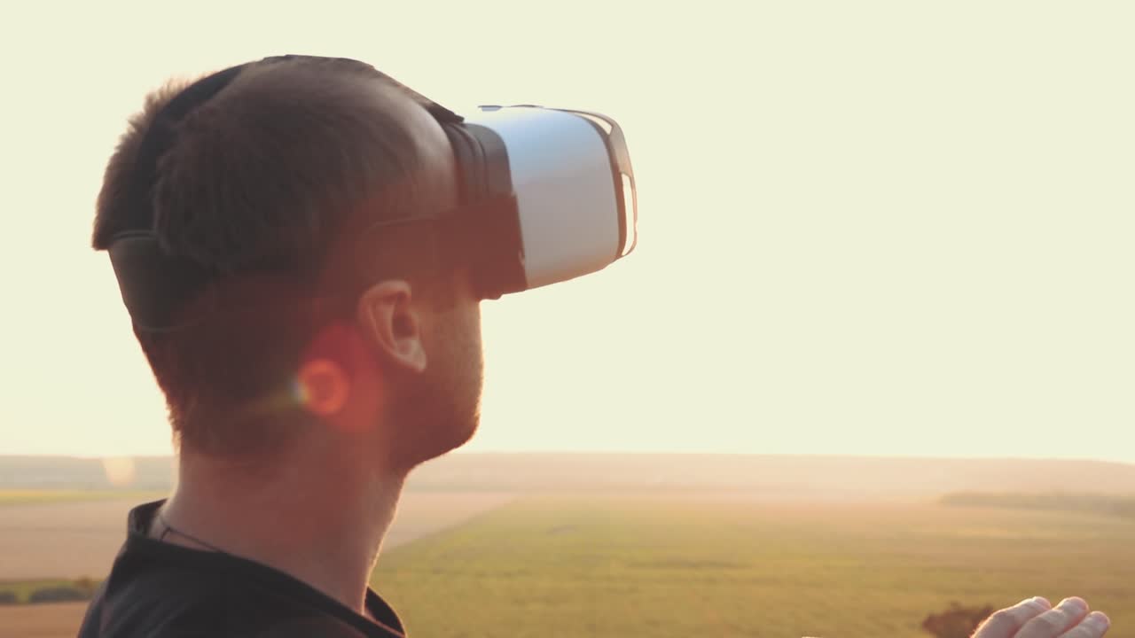 hombre experimentando auriculares de realidad virtual al atardecer