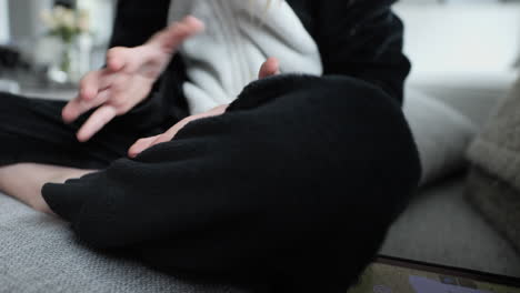 caucasian girl wearing onesie counts on fingers on sofa