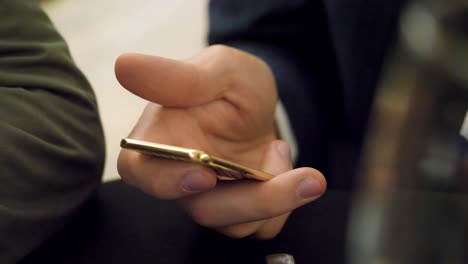 hombre con teléfono de oro y comedor