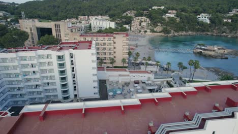 aerial orbit rising over holiday hotel in front the sea surrounded by rainforest