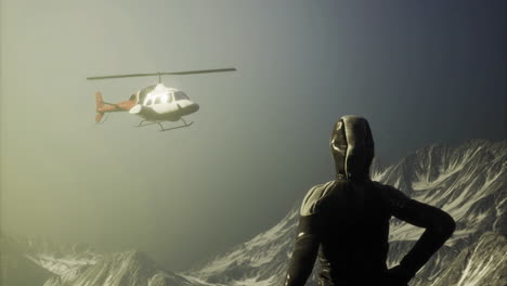 helicopter hover above snowy mountain peaks near a climber at sunset