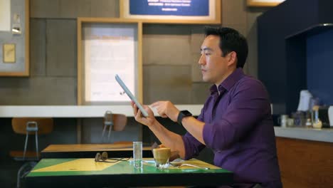 Hombre-Usando-Tableta-Digital-En-Cafetería-4k