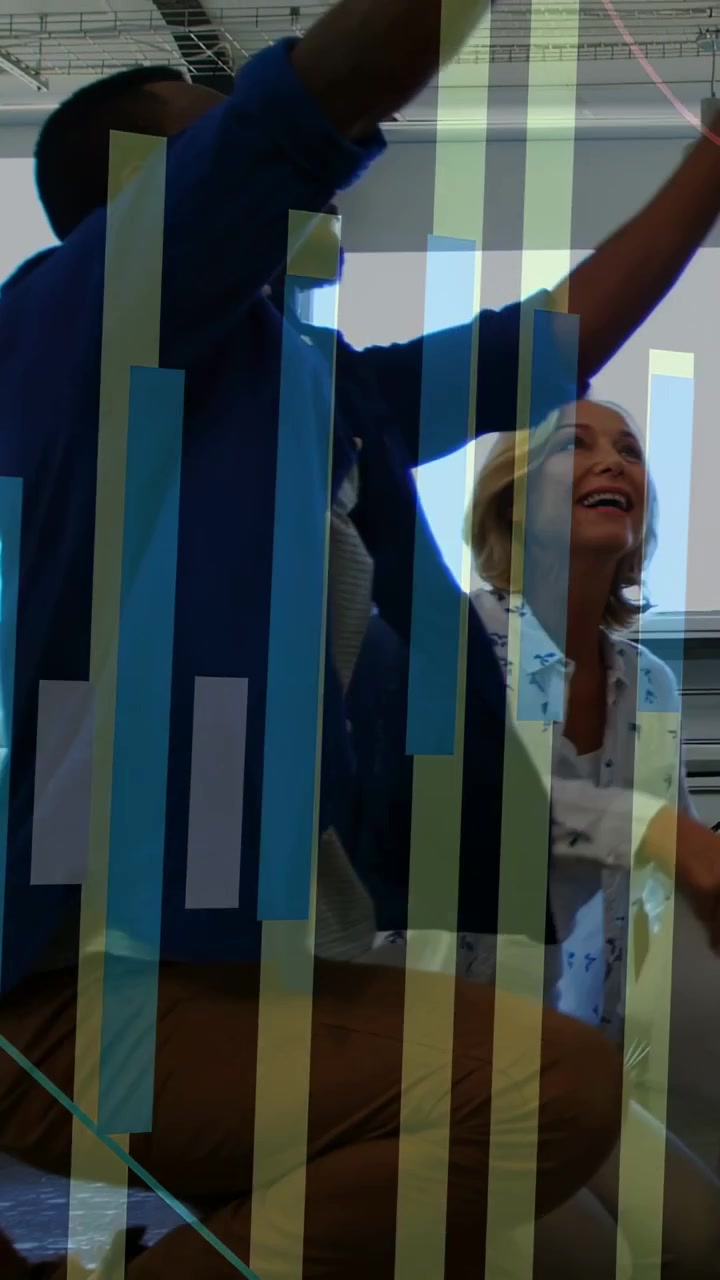 Uomo che indica un foglio, donna che lo rispecchia, alzando le braccia per celebrare un successo aziendale, grafico sovrapposto alle mani