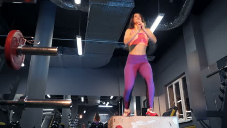 fitness woman jumping on box training at the gym, crossfit exercise. sports concept fat burning and a healthy lifestyle.